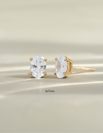 Gold 5x7mm oval stud earrings by Sami Jewels, front view showing smooth polished surface and classic jewelry style.