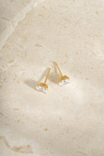 Back view of two gold 5x7mm oval studs showing their posts.