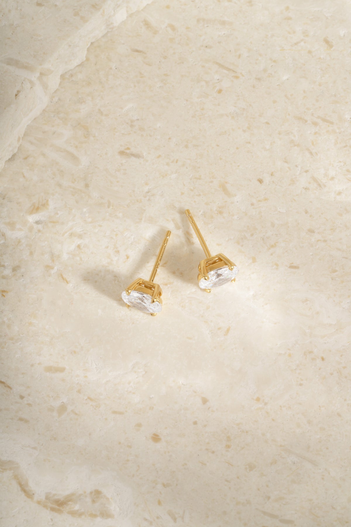 Back view of two gold 5x7mm oval studs showing their posts.
