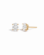 Gold 5x7mm oval CZ stud earrings shown from the front and side on white.
