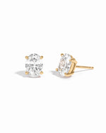 Gold 6x8mm oval CZ stud earrings shown from the front and side on white.