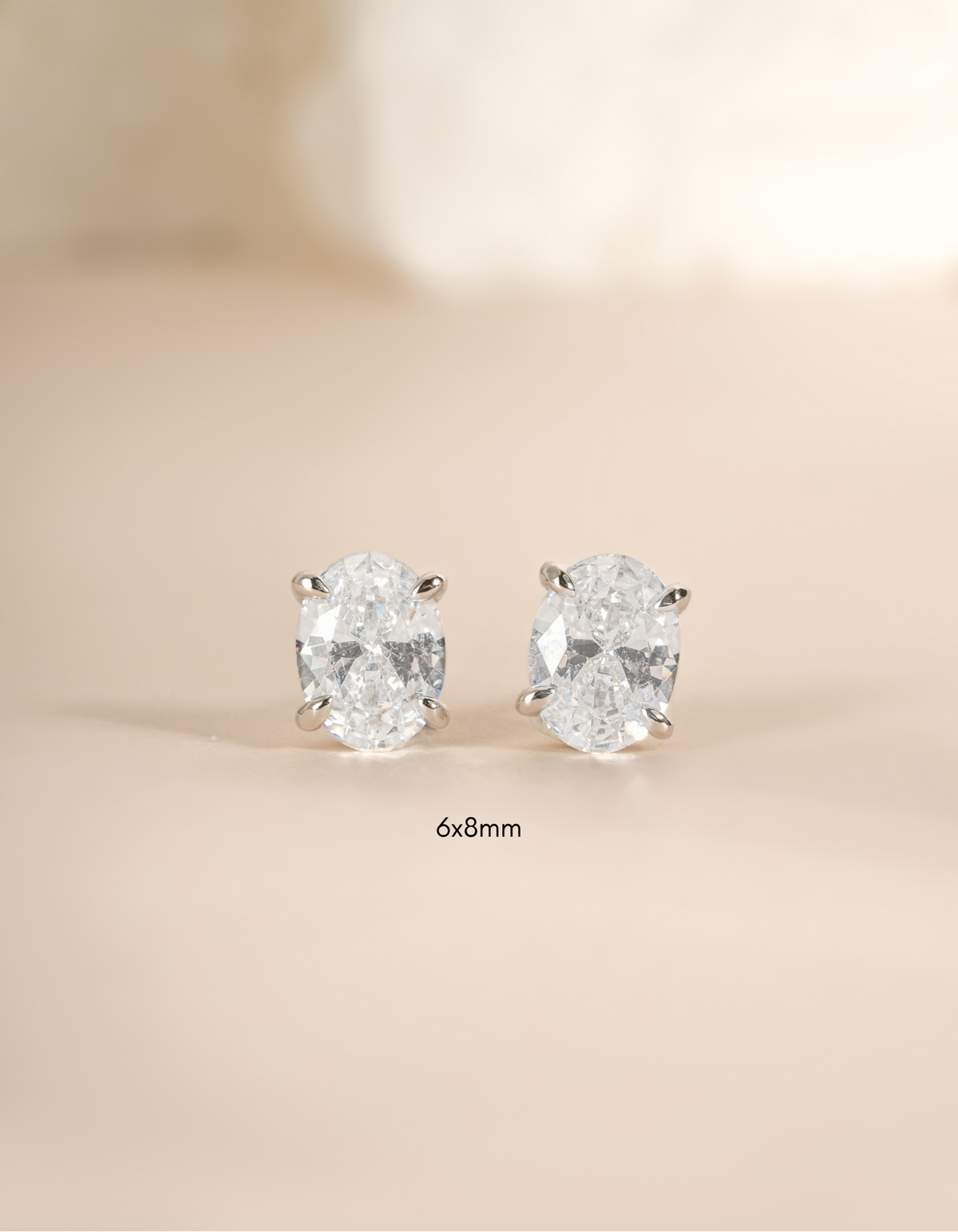 Pair of 6x8mm oval silver stud earrings by Sami Jewels featuring polished sterling silver design.