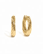 Gold oval textured hoop earrings by Sami Jewels displayed on a white background. Stylish, lightweight jewelry for everyday wear.