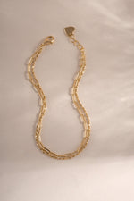 Close-up of gold paperclip and chain bracelet set from Sami Jewels, showcasing modern jewelry design and craftsmanship.