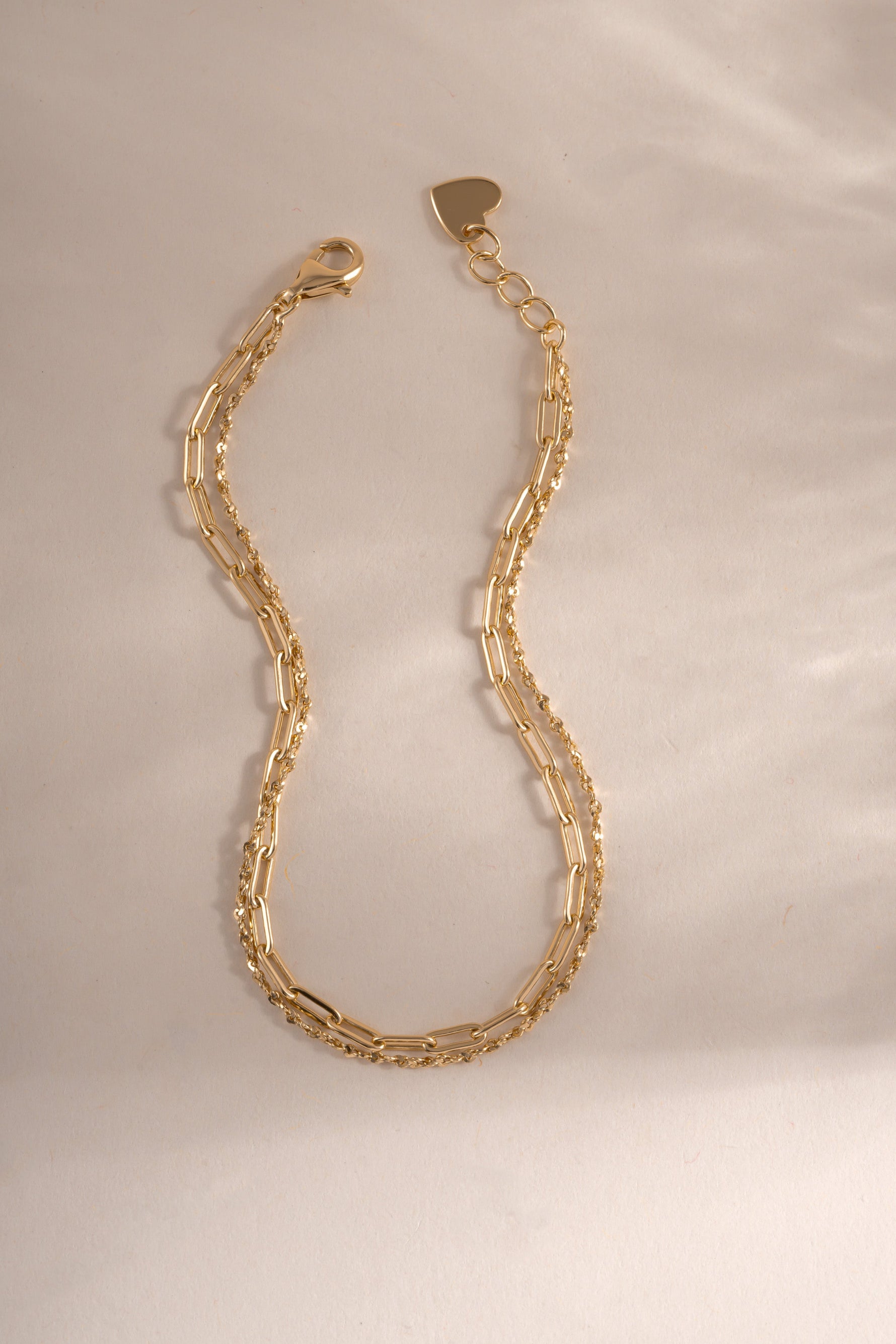 Close-up of gold paperclip and chain bracelet set from Sami Jewels, showcasing modern jewelry design and craftsmanship.