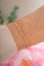 Gold paperclip and chain bracelet set from Sami Jewels featuring sleek, modern jewelry on a model.