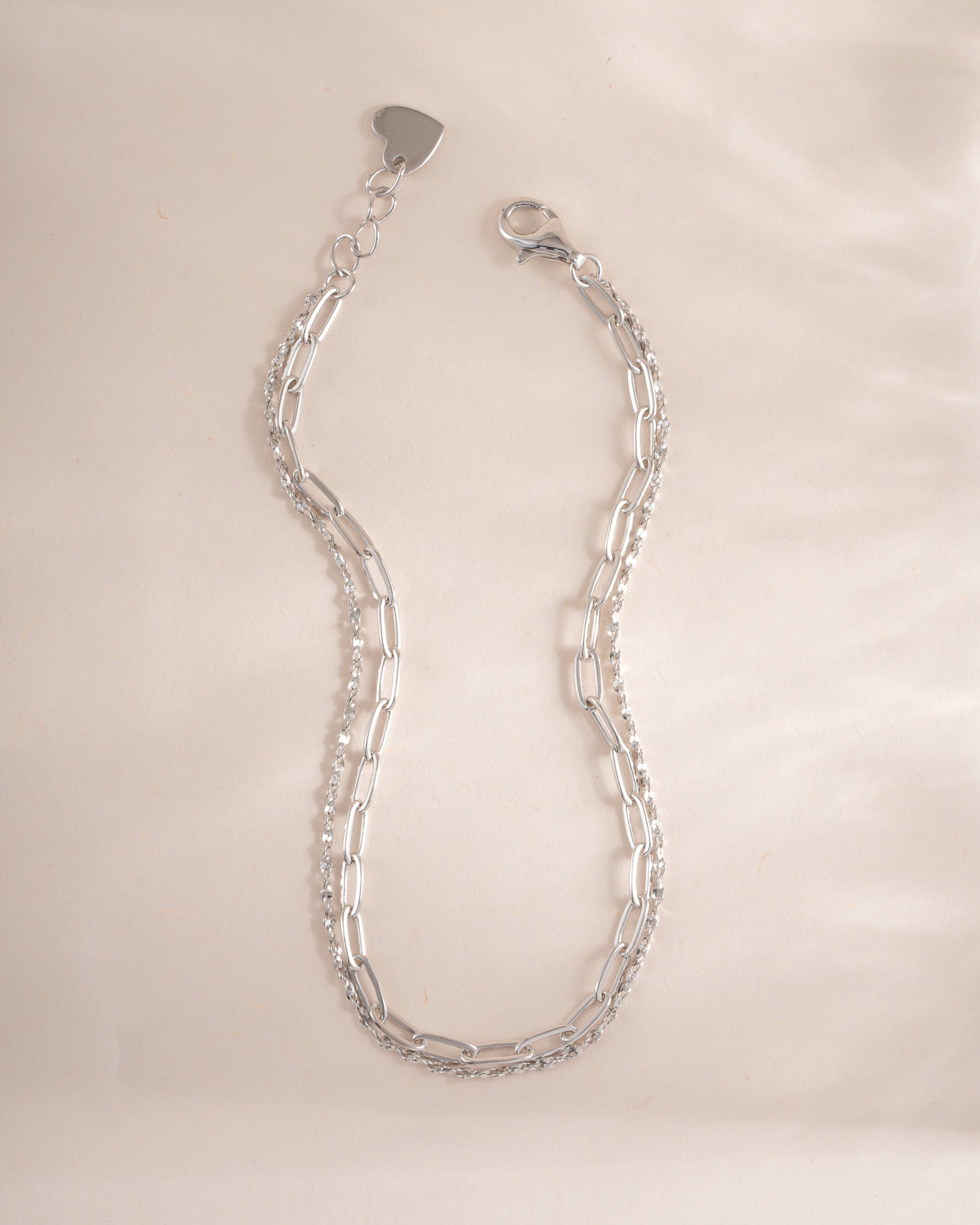 Close-up of Sami Jewels paperclip and chain bracelet set in sterling silver, showcasing sleek, modern jewelry designs.