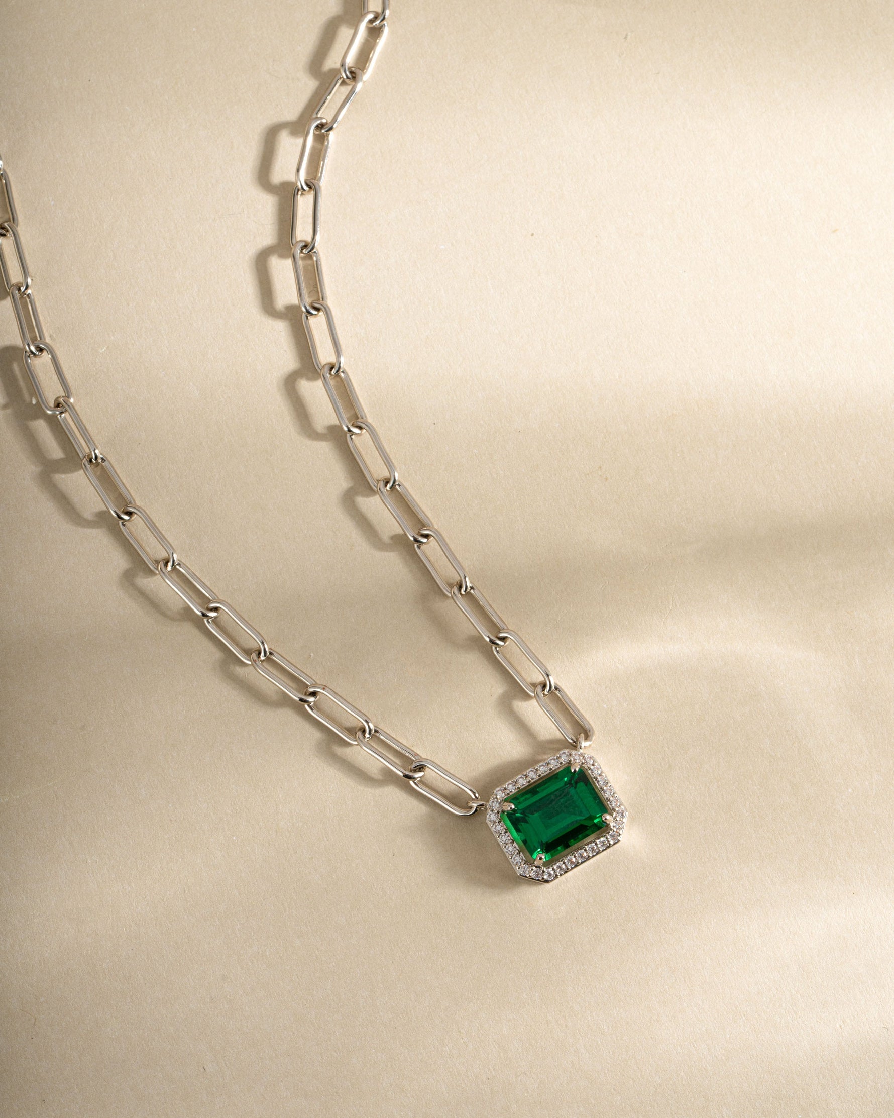 Silver paperclip necklace with emerald pendant from Sami Jewels, front view showing sleek design and vibrant green gemstone.