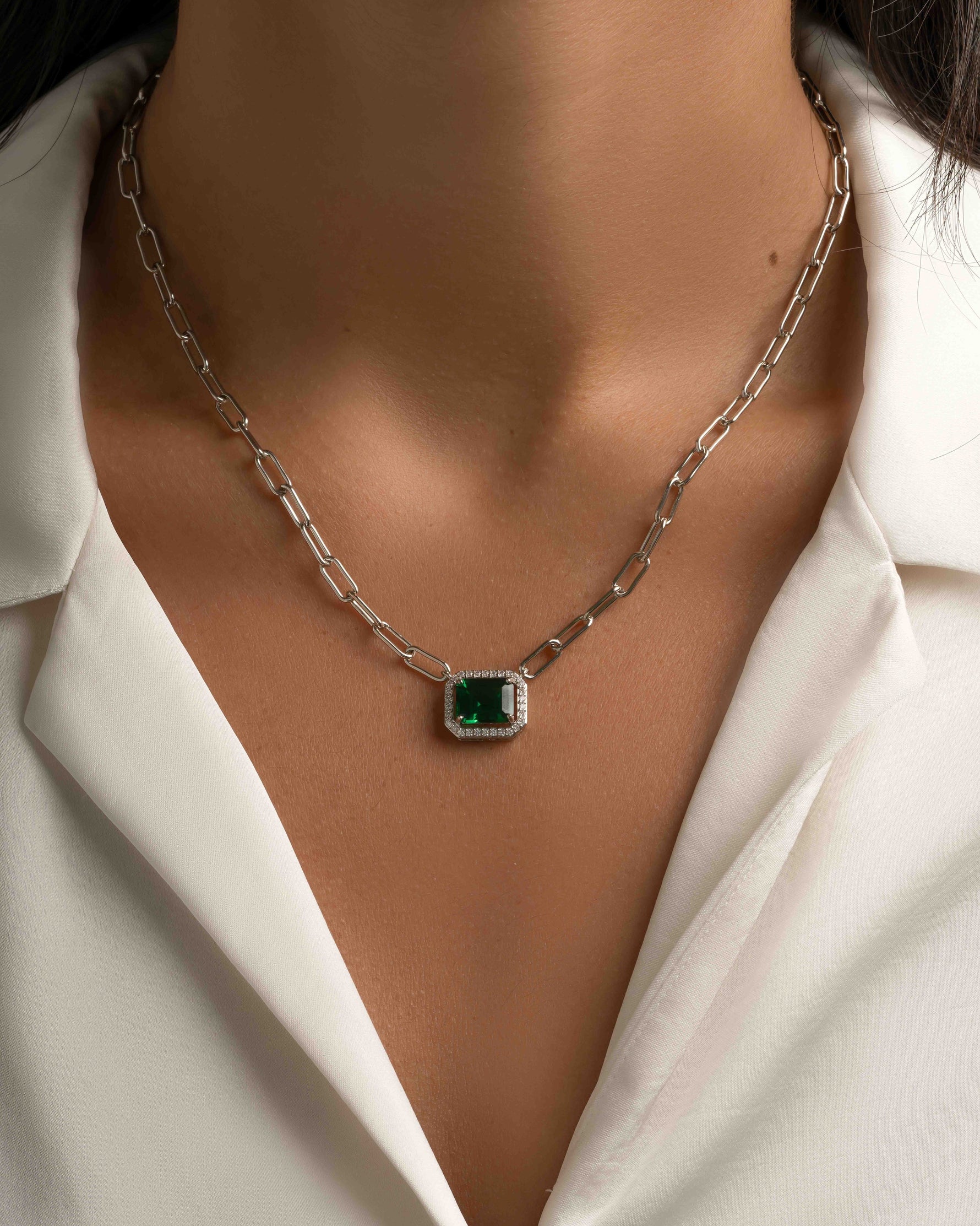 Silver paperclip necklace with emerald pendant from Sami Jewels, showcasing a sleek and modern jewelry design.