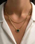Gold paperclip pendant necklace with emerald charm, layered style, worn by a model, by Sami Jewels.