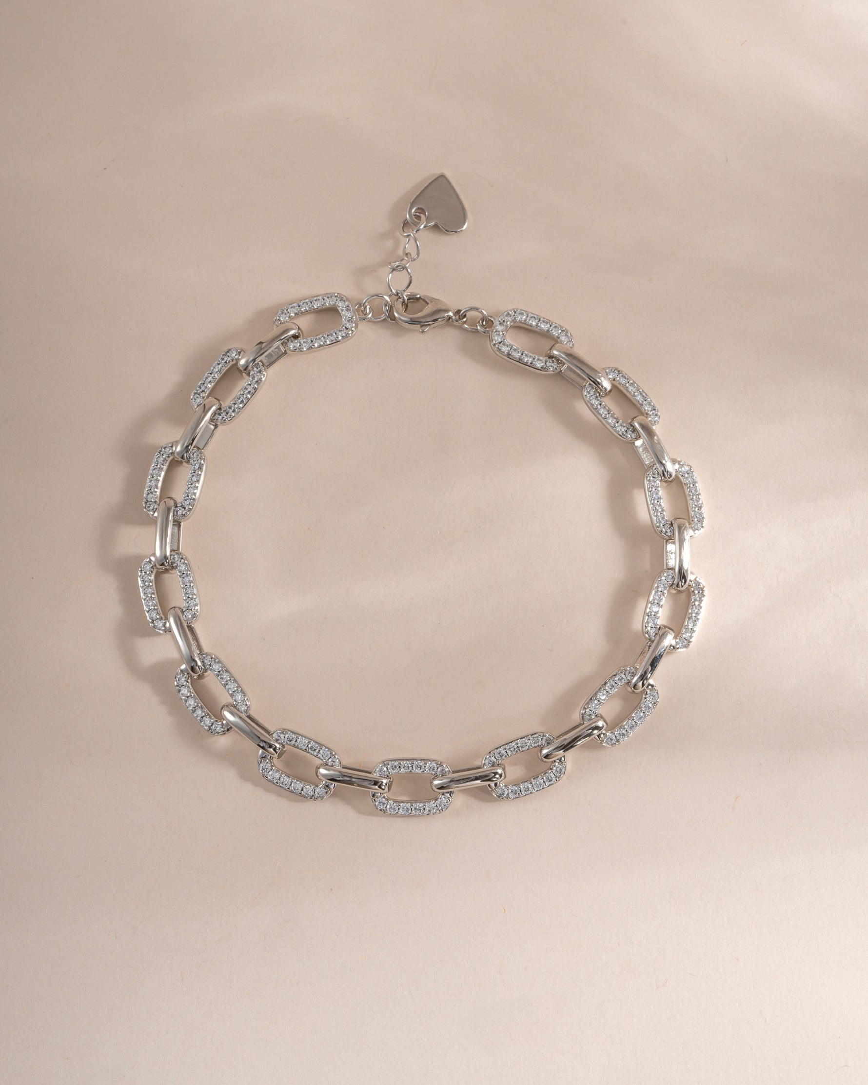 Silver pave chain link bracelet from Sami Jewels, showing a close-up of the intricate chain design on a flat surface.