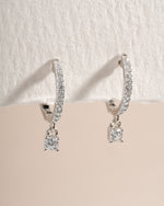 Sterling silver Pavé Charm Huggies earrings with sparkling pave design, angled view showcasing intricate craftsmanship.