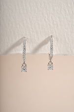 Close-up of sterling silver Pavé Charm Huggies earrings by Sami Jewels, showcasing their sparkling pave design and small hoop style.
