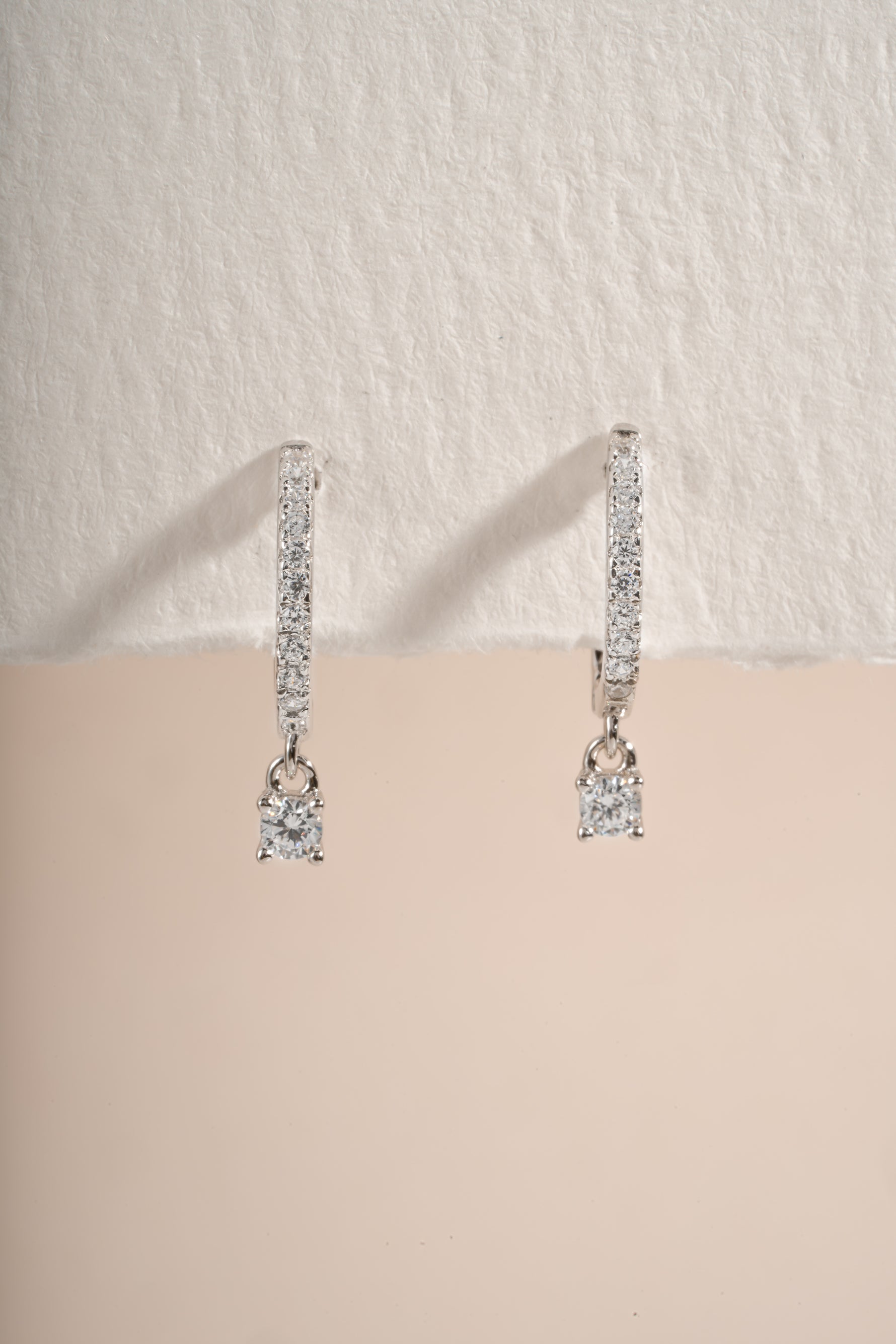 Close-up of sterling silver Pavé Charm Huggies earrings by Sami Jewels, showcasing their sparkling pave design and small hoop style.