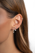 Sterling silver Pavé Charm Huggies earrings with sparkling stones, designed by Sami Jewels, worn on a model.