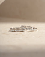 Sterling silver 11mm pavé diamond huggie earrings by Sami Jewels featuring sparkling pave design and sleek hoop style.