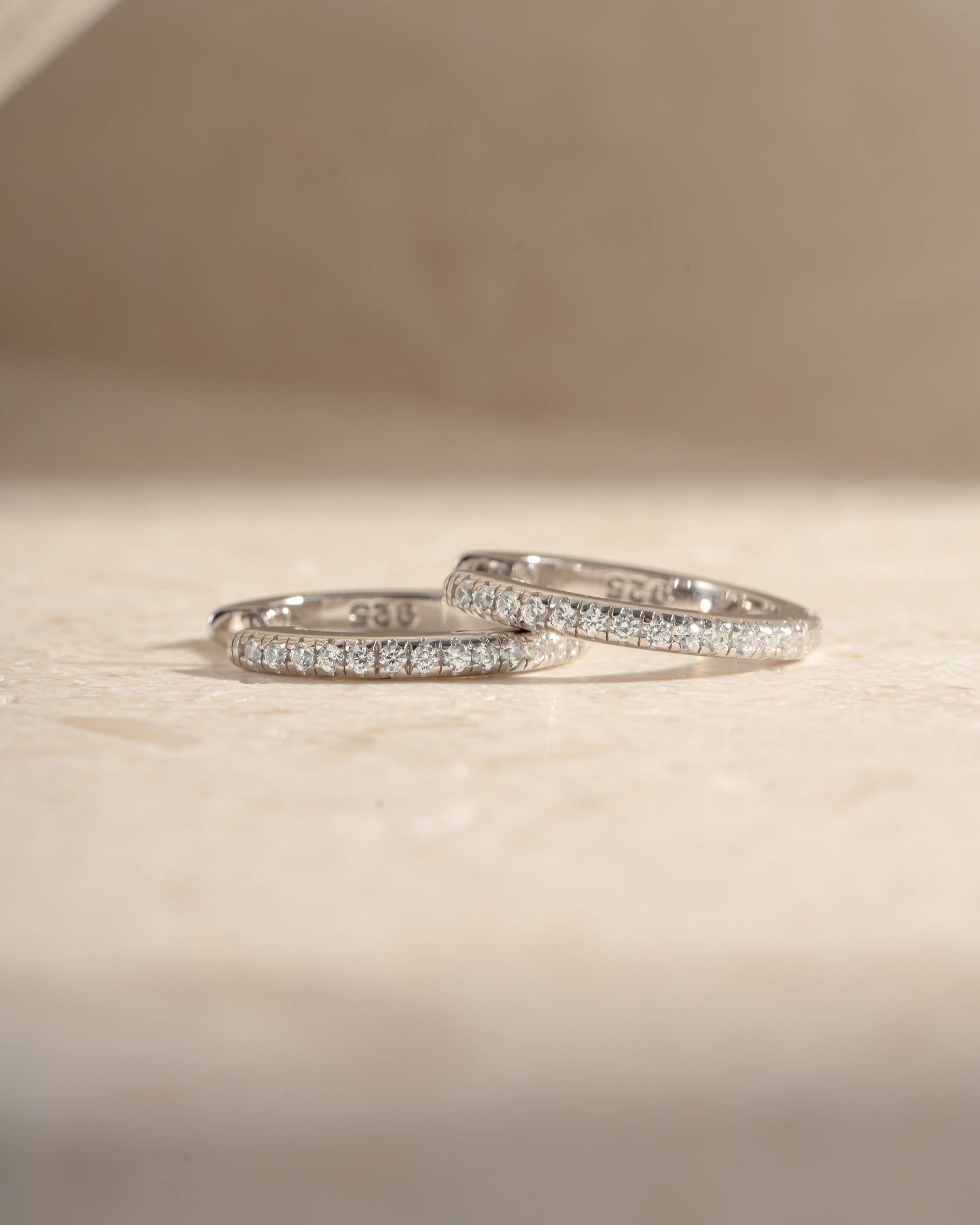 Sterling silver 11mm pavé diamond huggie earrings by Sami Jewels featuring sparkling pave design and sleek hoop style.