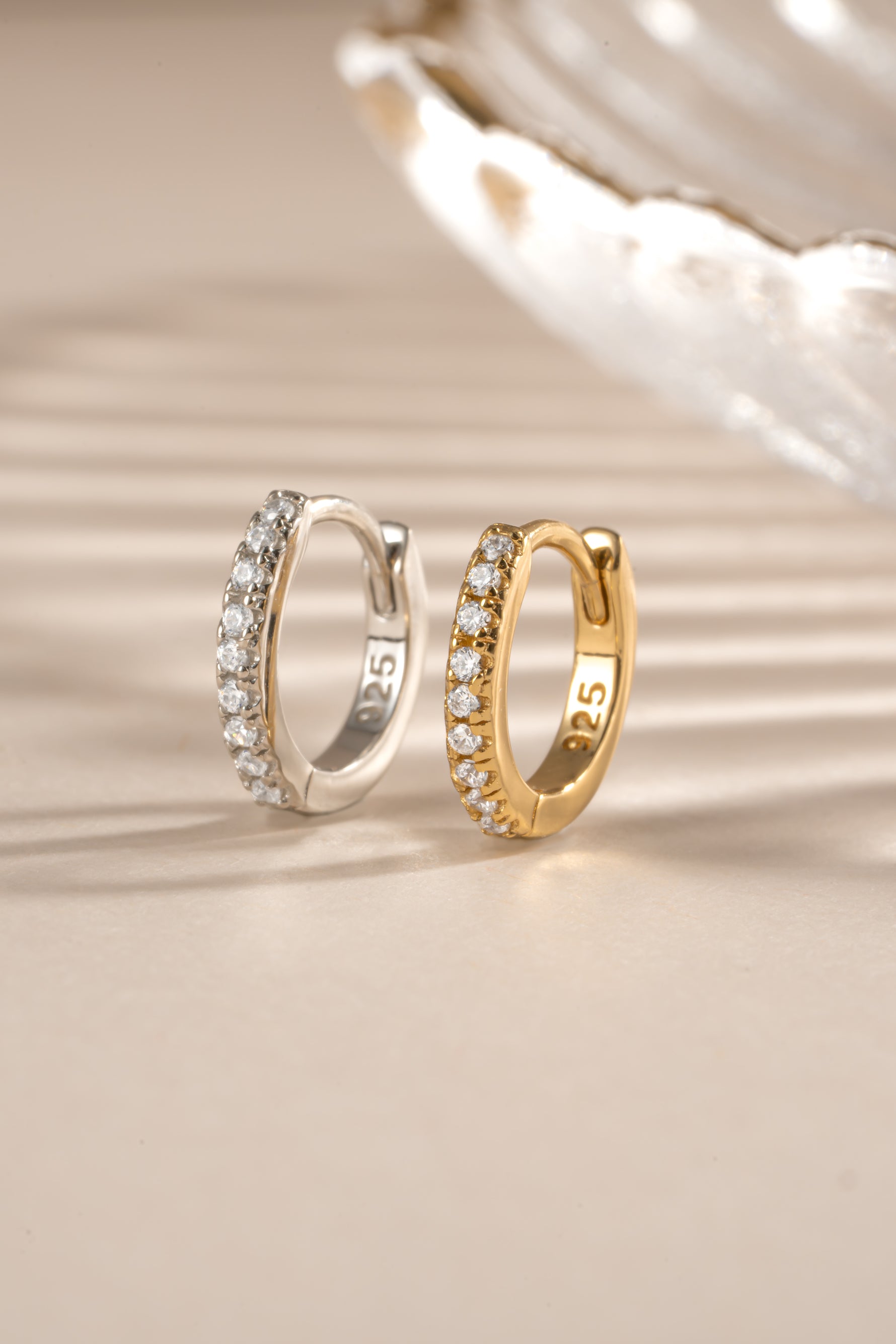 Gold and sterling silver 6mm CZ huggie earrings with pave diamond design by Sami Jewels.