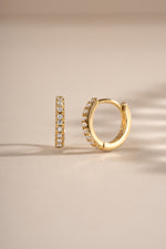 Close-up of 6mm gold CZ huggie earrings with pave diamond design by Sami Jewels.