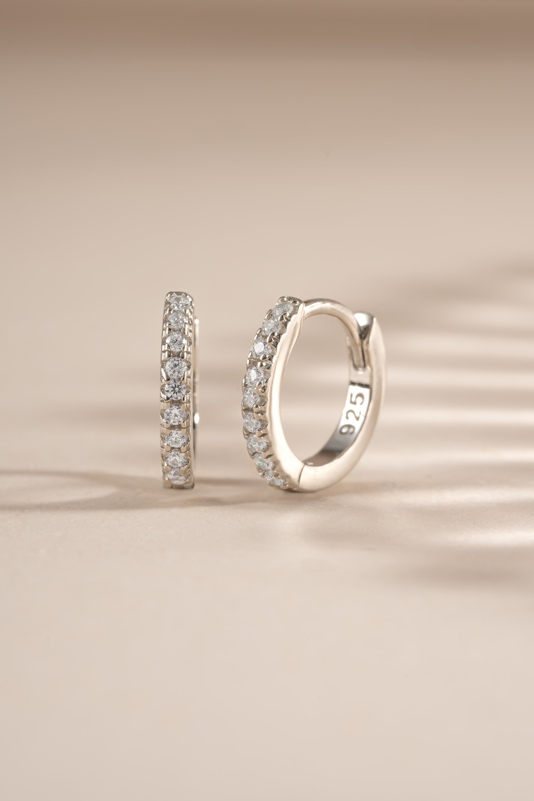 Sterling silver 6mm CZ huggie earrings with pave diamond accents from Sami Jewels, showcasing their elegant, close-fitting hoop design.