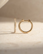 Gold 11mm pavé diamond huggie earrings by Sami Jewels, side view showcasing sparkling pave setting and compact hoop design.