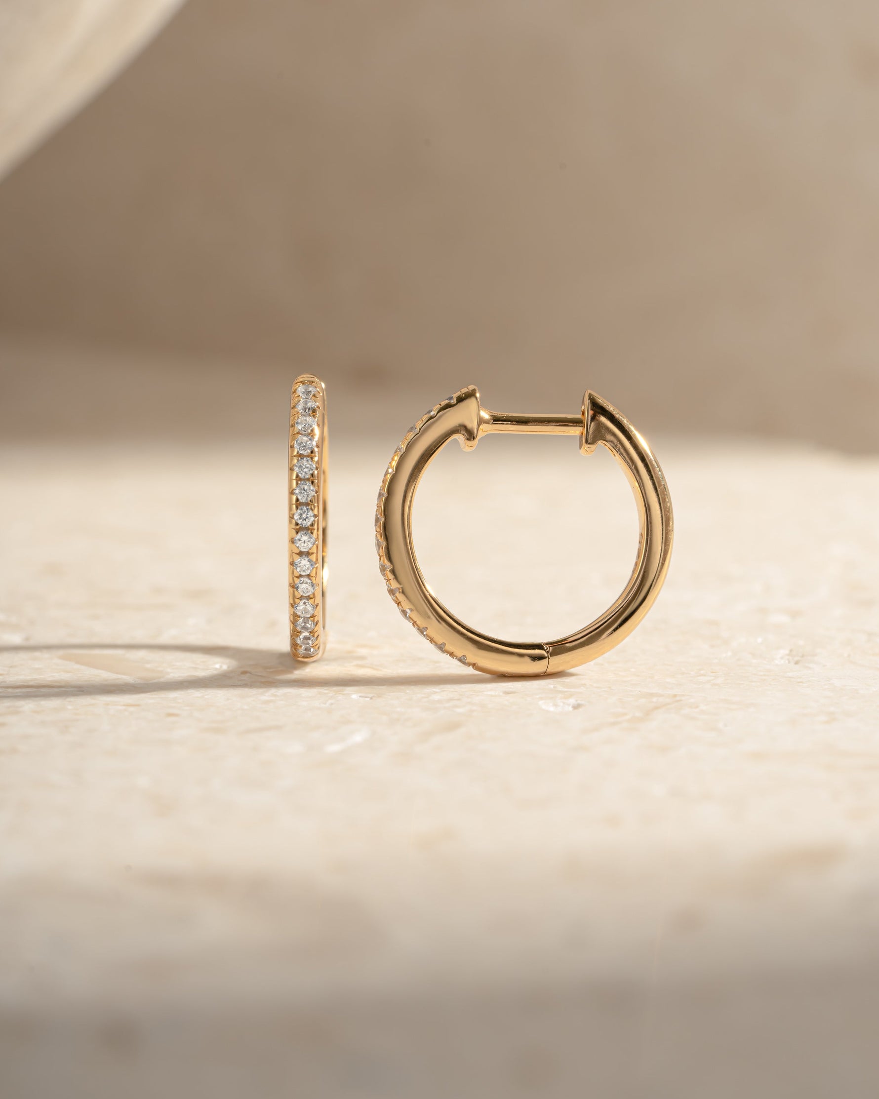Gold 11mm pavé diamond huggie earrings by Sami Jewels, side view showcasing sparkling pave setting and compact hoop design.
