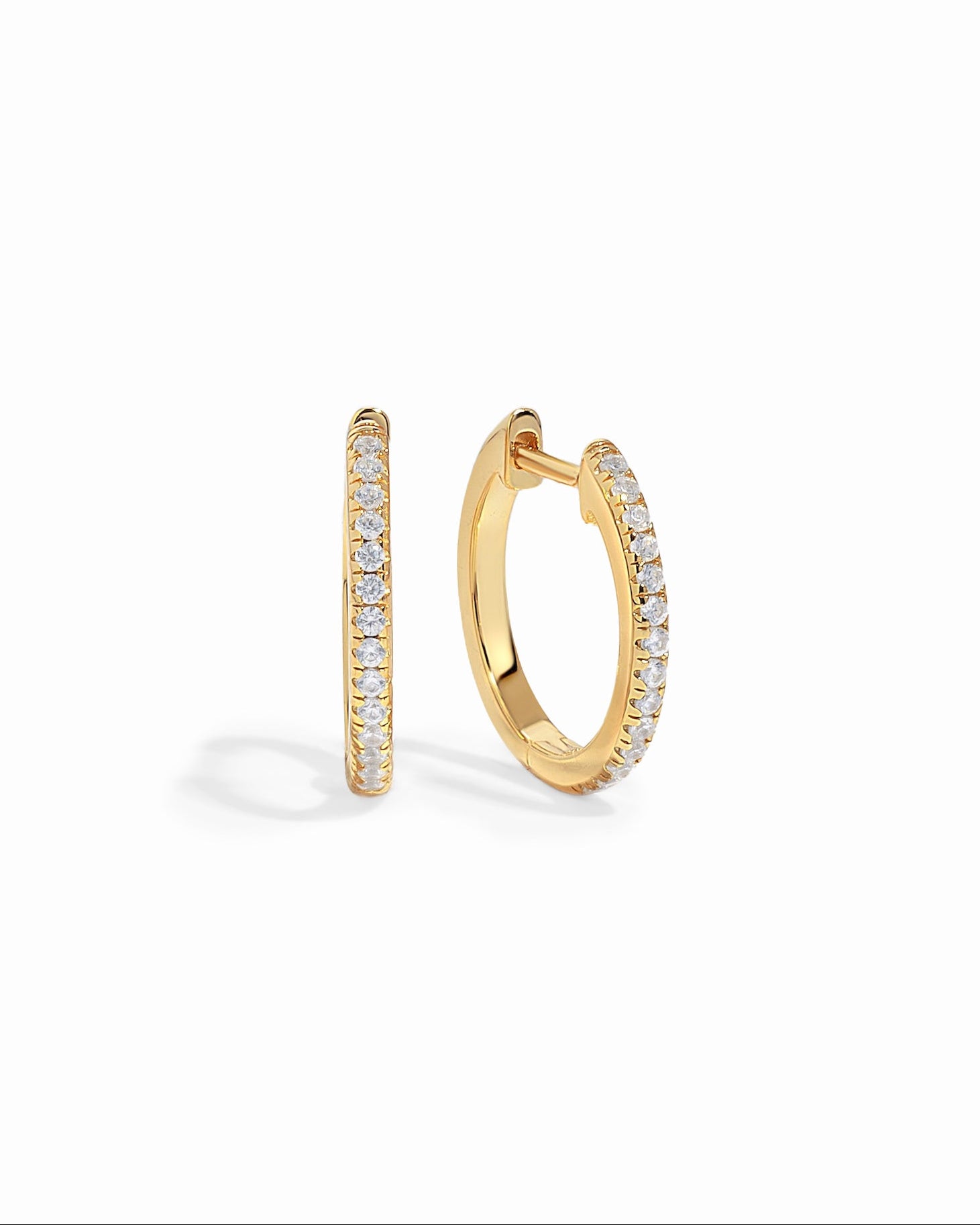 Gold 11mm pavé diamond huggie earrings by Sami Jewels with sparkling diamond details on a white background.