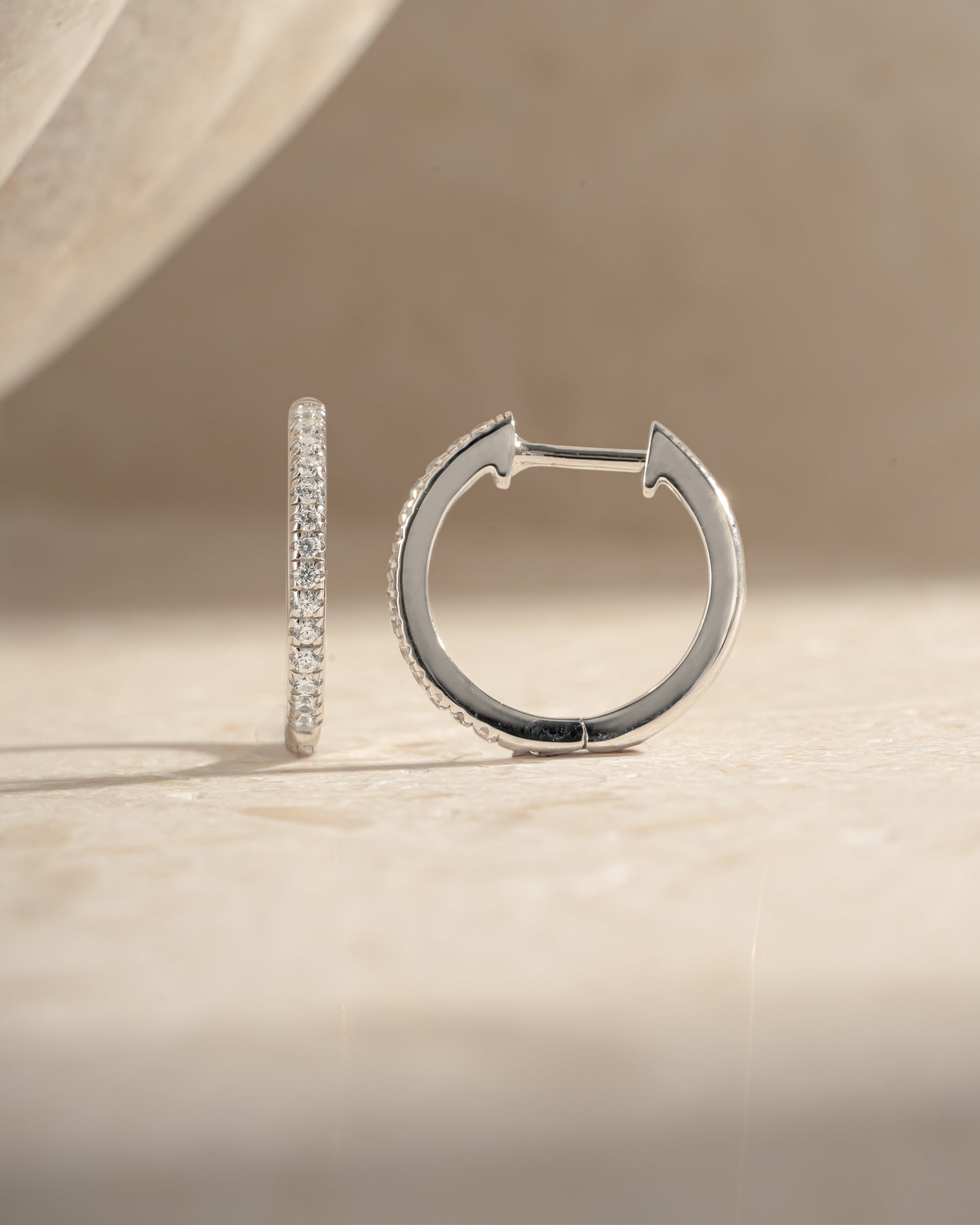 Sterling silver 11mm pavé diamond huggie earrings by Sami Jewels, side view showing sparkling pave design and small hoop size