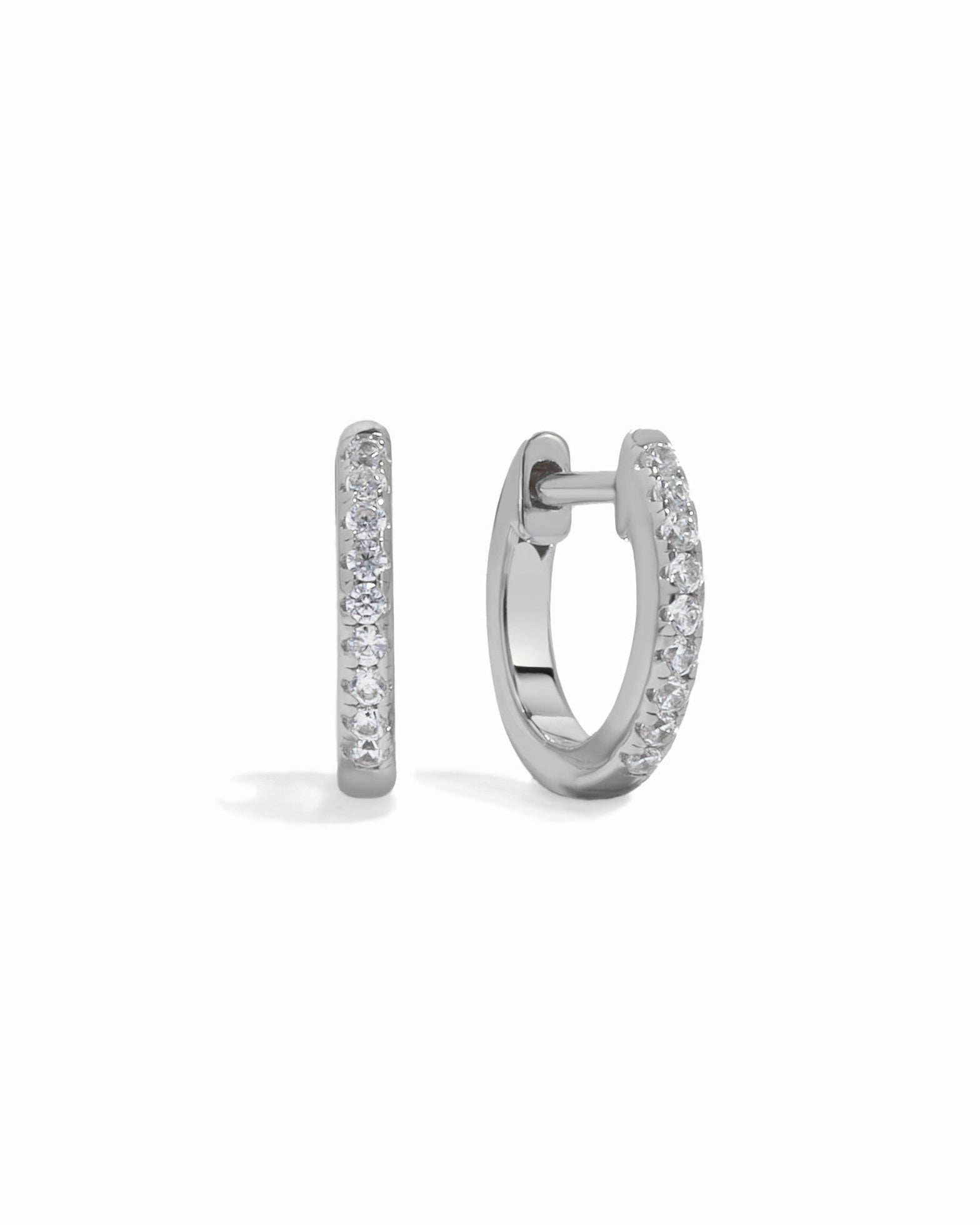 Sterling silver 8mm pavé diamond huggie earrings by Sami Jewels with sparkling tiny diamonds on a white background