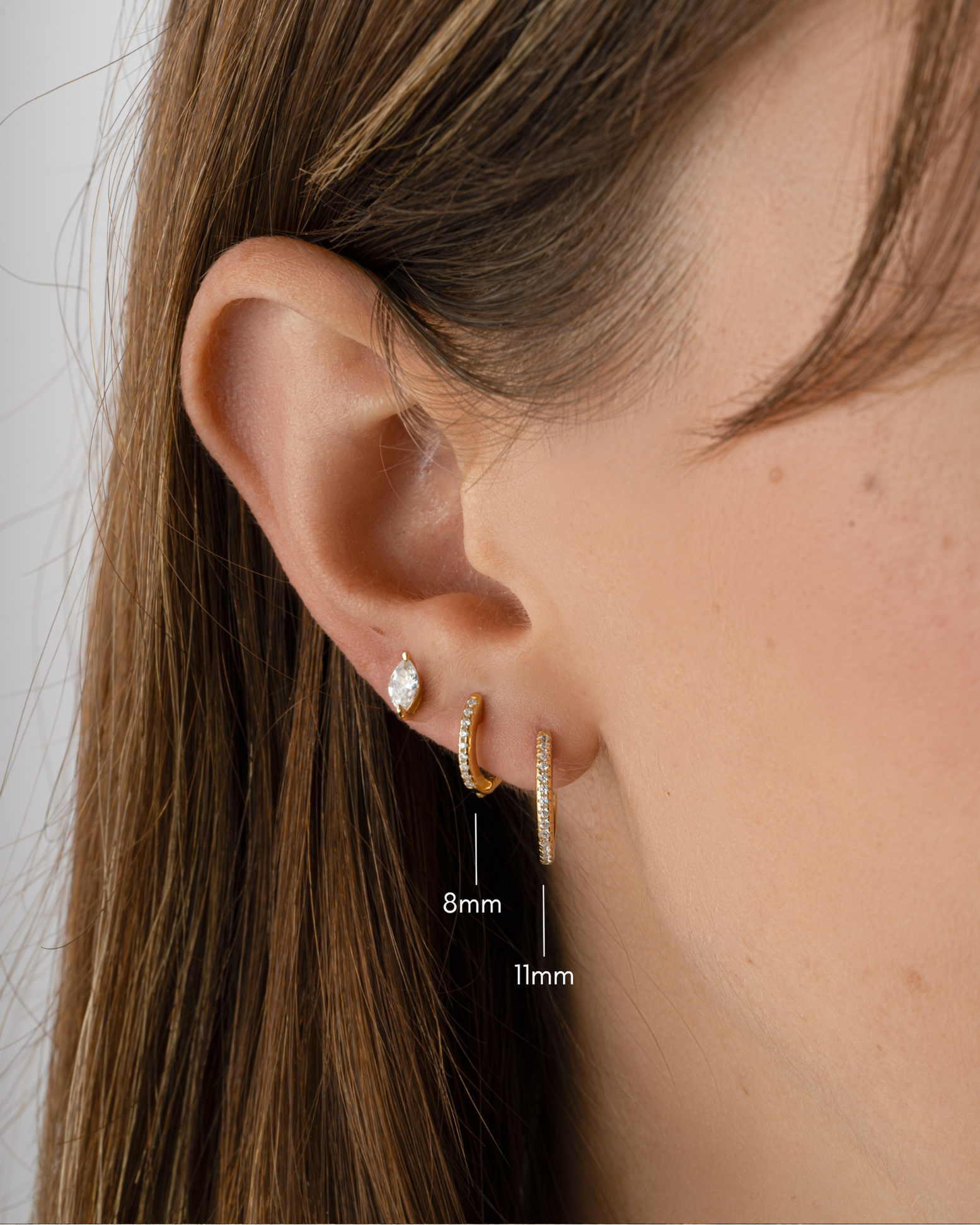 Pair of Sami Jewels 11mm pavé diamond gold huggie earrings with two size options, showcasing sparkling diamond details and sleek design.