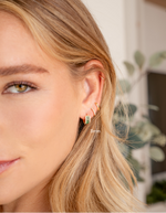 Gold 8mm pavé diamond huggie earrings by Sami Jewels, close-up of sparkling small and large hoop earrings on model.