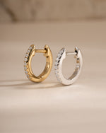Gold and sterling silver 8mm pavé diamond huggie earrings by Sami Jewels, showcasing sparkling pave design and classic hoop style.