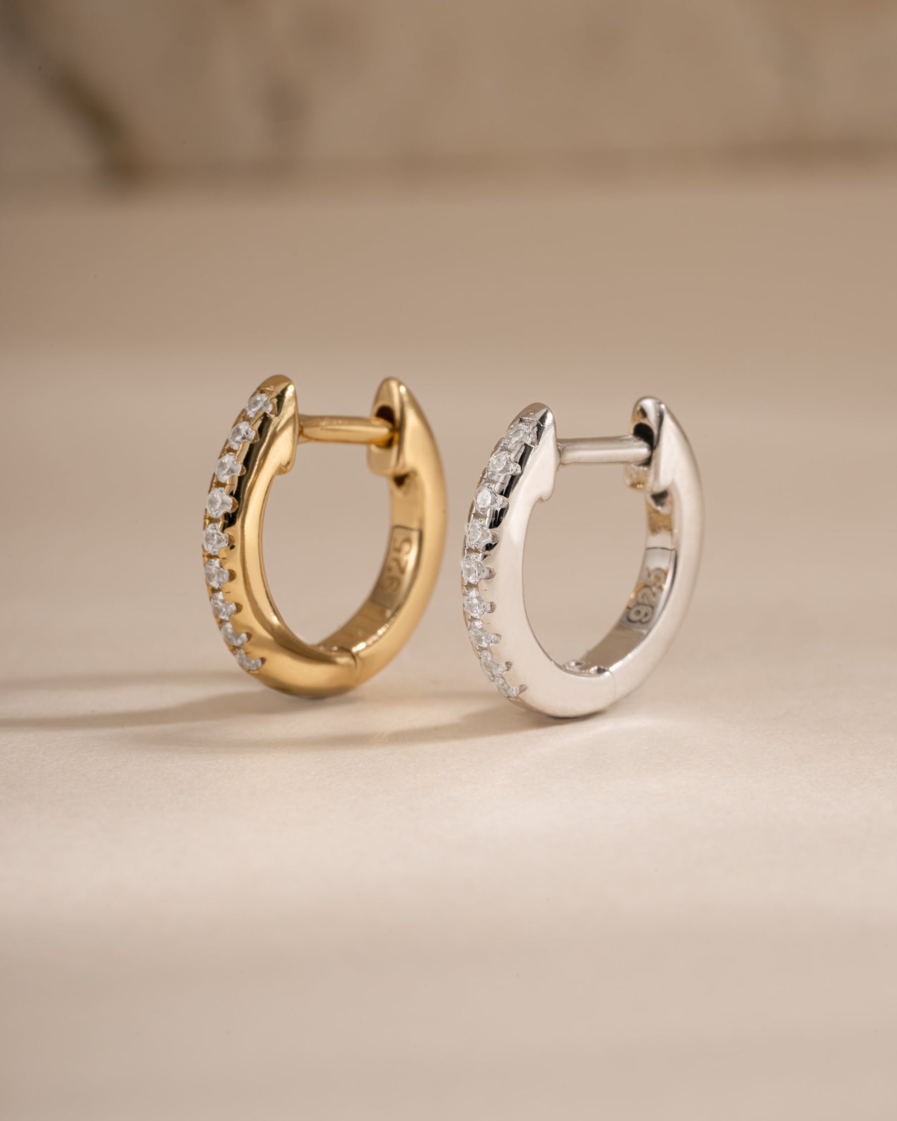 Gold and sterling silver 8mm pavé diamond huggie earrings by Sami Jewels, showcasing sparkling pave design and classic hoop style.