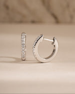 Sterling silver 8mm pavé diamond huggie earrings by Sami Jewels showcasing sparkling pave diamonds and a close-fitting hoop design.