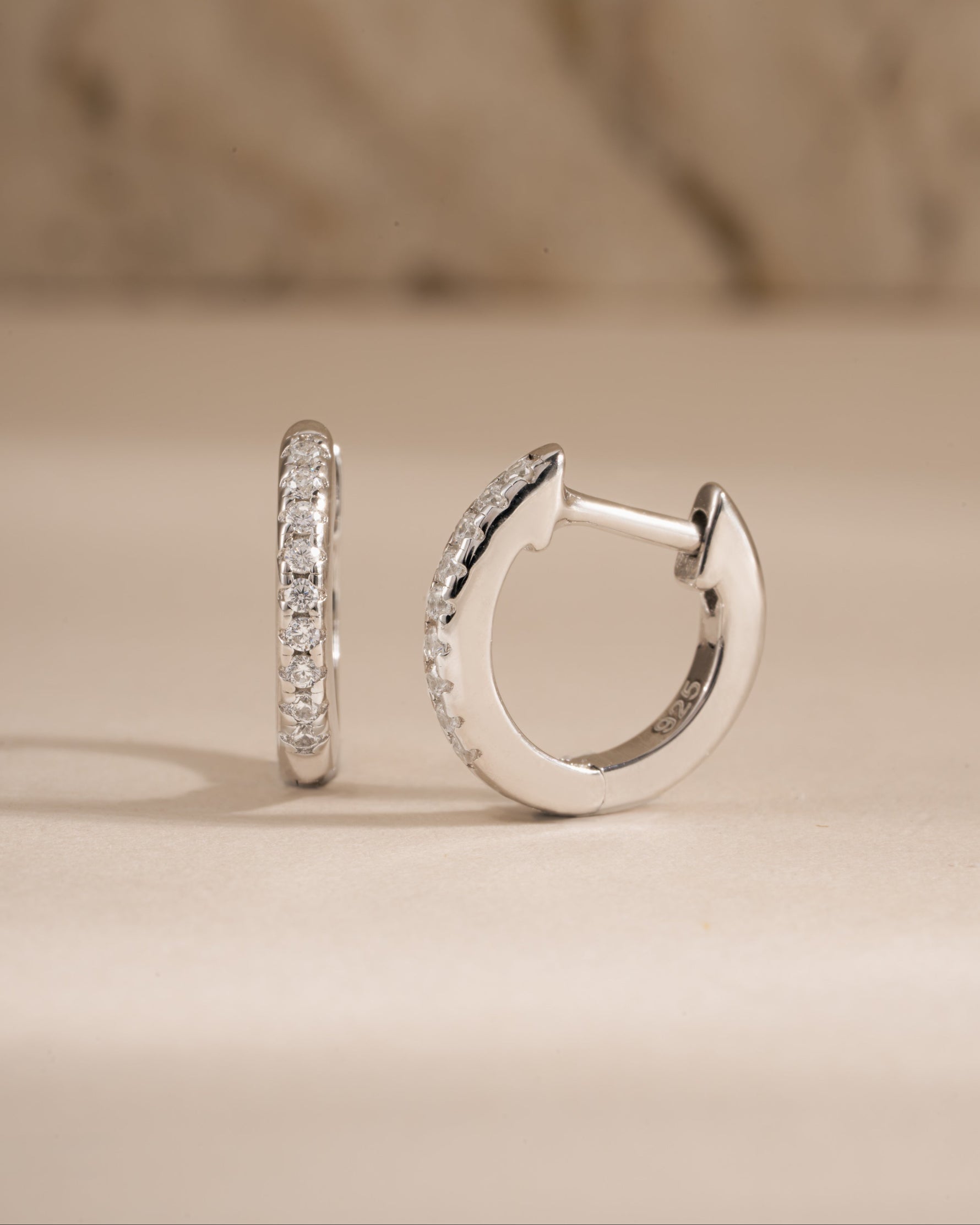 Sterling silver 8mm pavé diamond huggie earrings by Sami Jewels showcasing sparkling pave diamonds and a close-fitting hoop design.