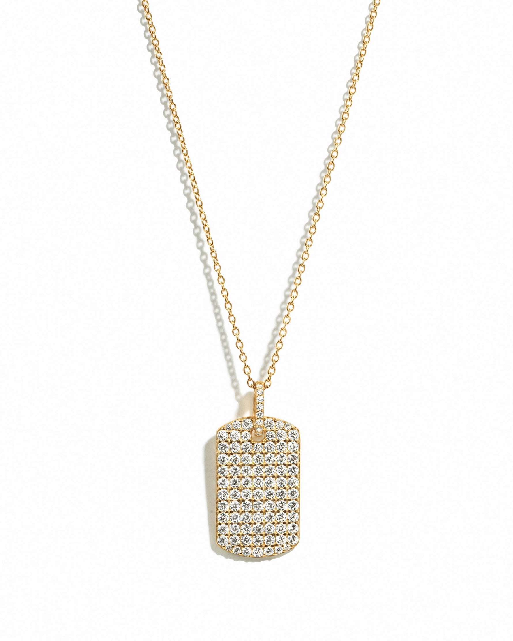 Gold pavé dog tag necklace from Sami Jewels displayed on a white background with detailed pave design.