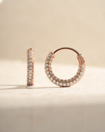 Rose gold 14mm pavé hoop earrings by Sami Jewels showcasing sparkling small gemstones on a sleek hoop design.
