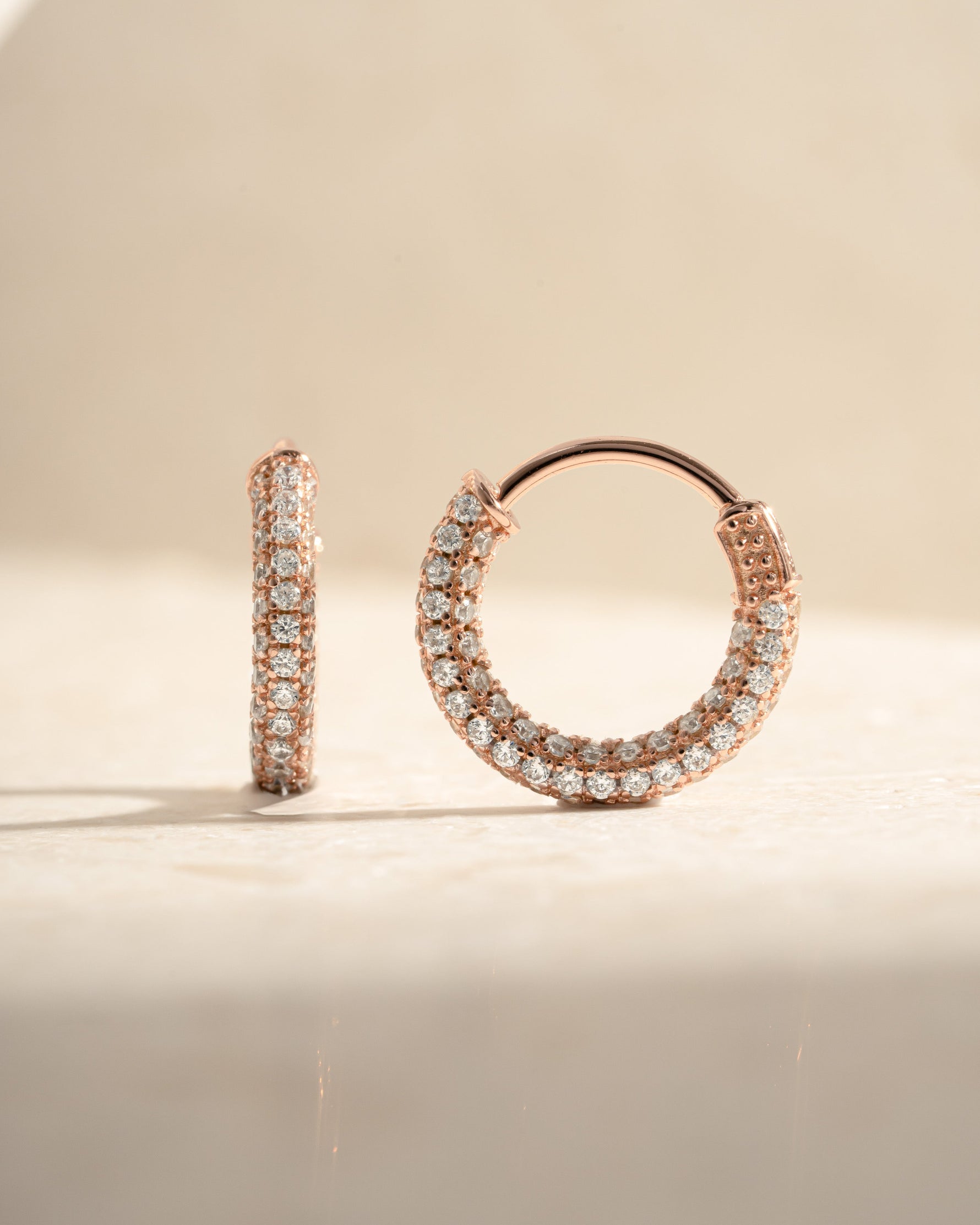 Rose gold 14mm pavé hoop earrings by Sami Jewels showcasing sparkling small gemstones on a sleek hoop design.