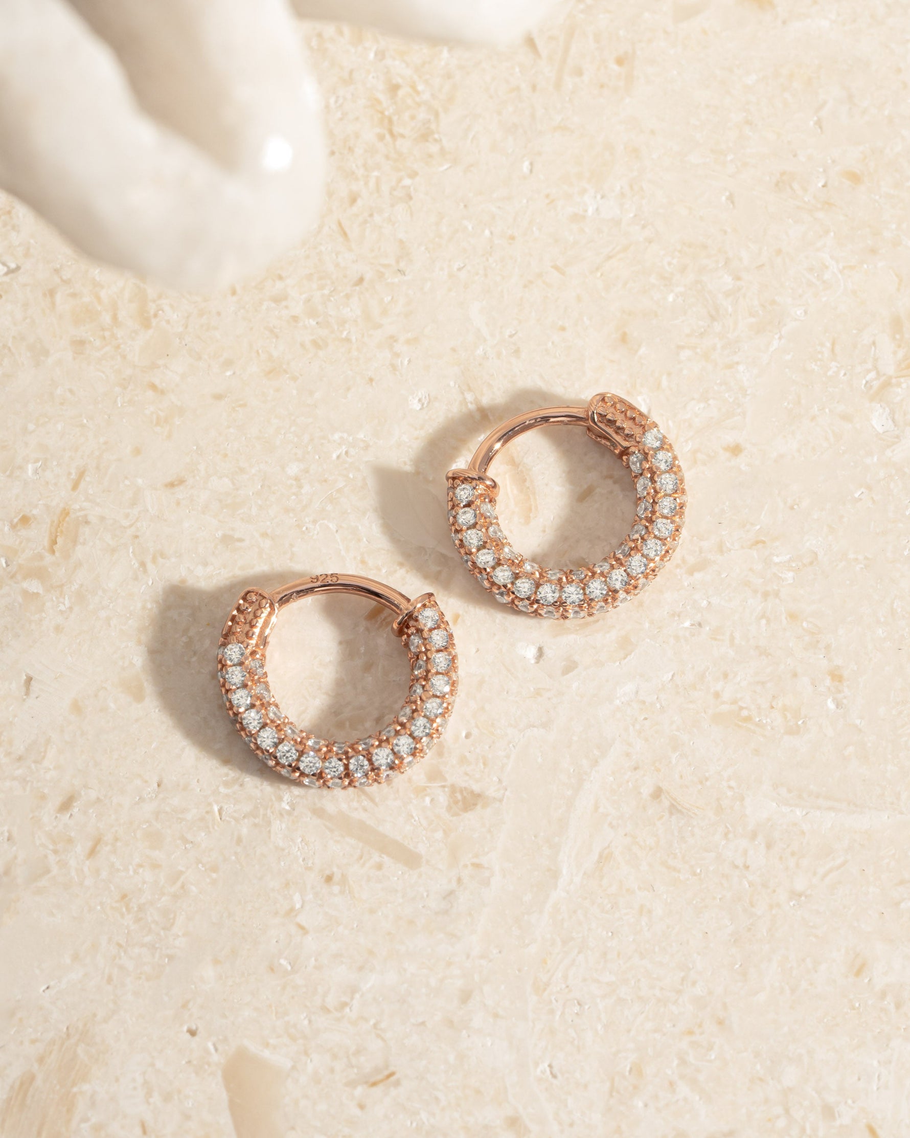 Rose gold 12mm pavé hoop earrings by Sami Jewels, showcasing sparkling pave detailing and a stylish hoop design.