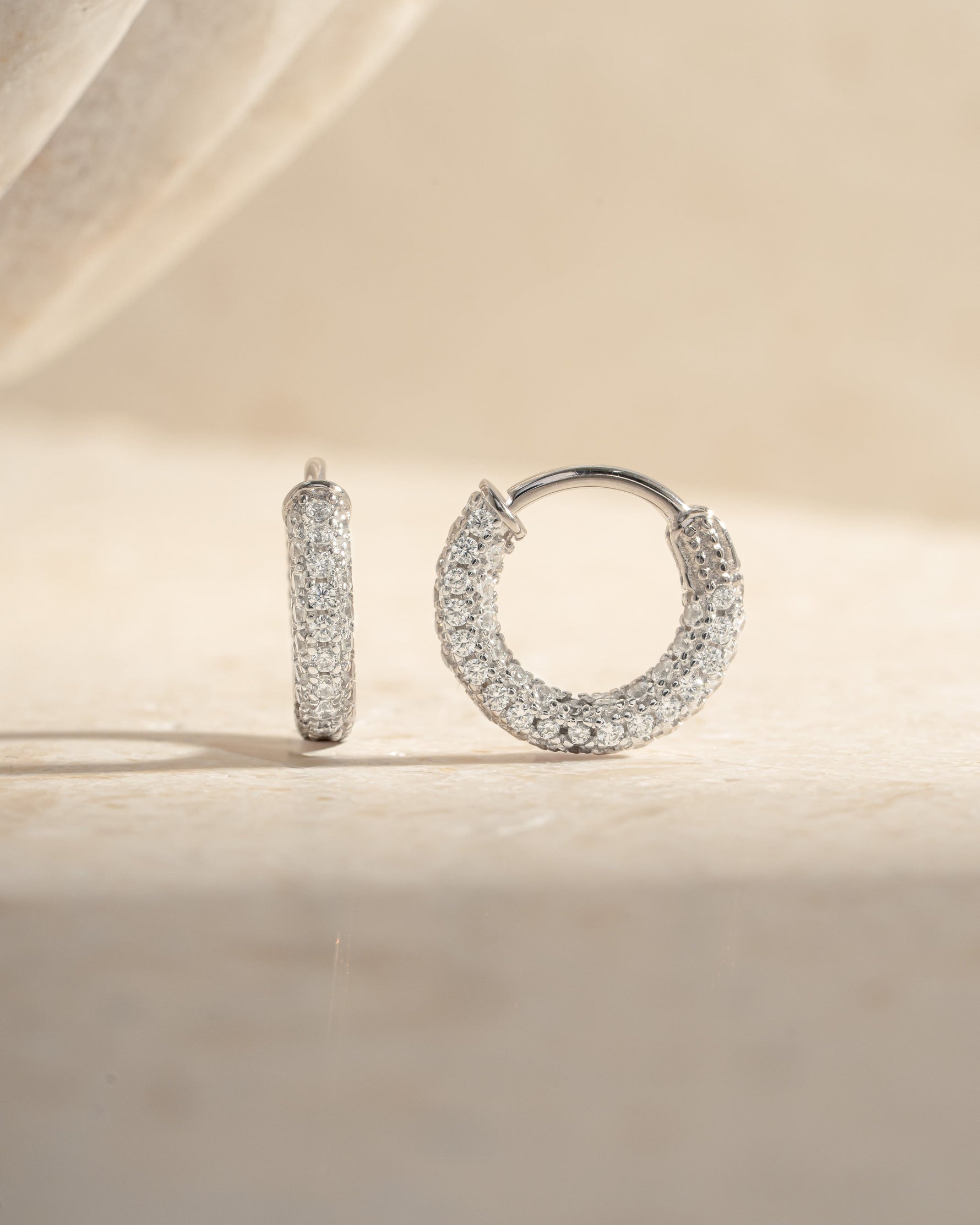 Close-up of 12mm sterling silver pavé hoop earrings by Sami Jewels, showcasing sparkling tiny stones and sleek hoop design.