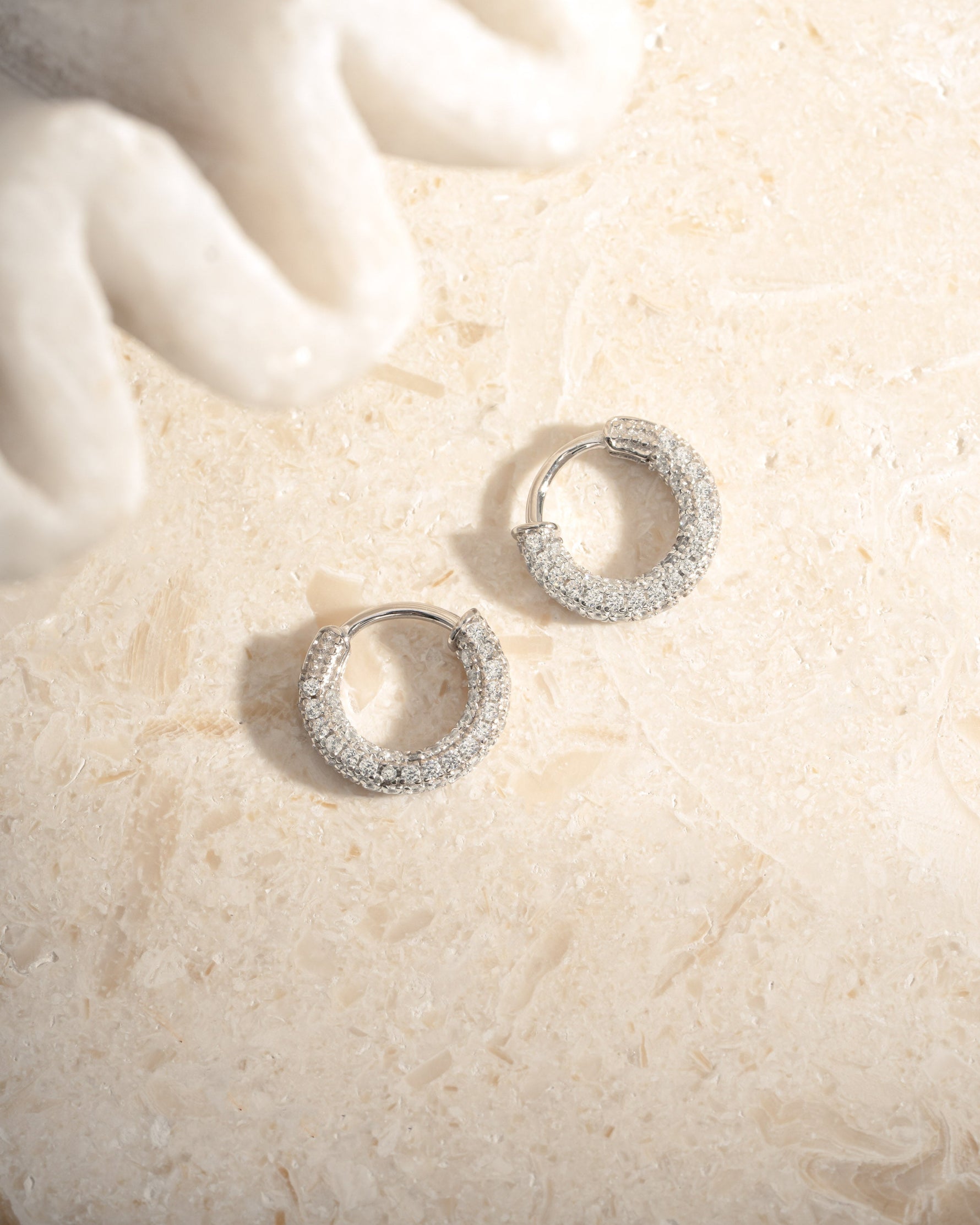 Sterling silver 12mm pavé hoop earrings by Sami Jewels featuring sparkling, embedded tiny gemstones in a classic hoop design.