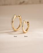 Gold 11mm pavé huggie earrings by Sami Jewels, shown in two different sizes with sparkling pavé detailing.