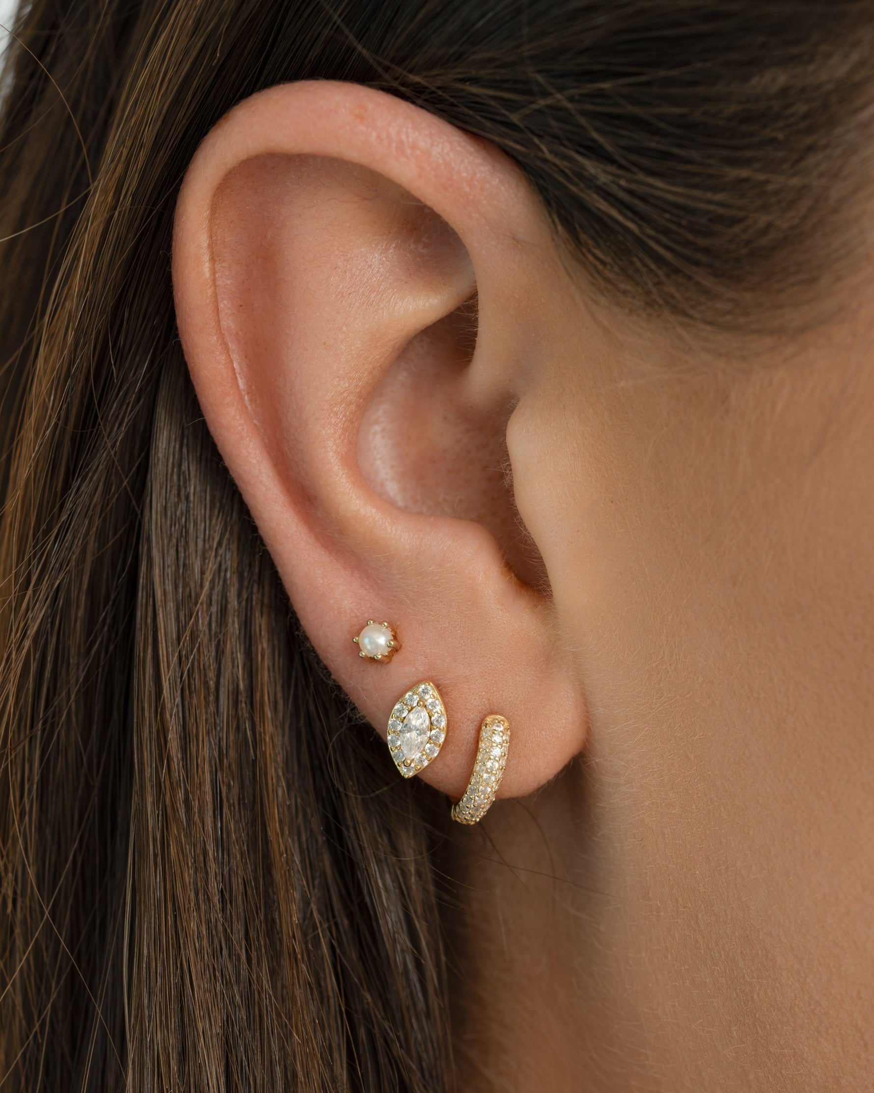 Stacked Sami Jewels Halo Marquise Stud Earrings with pave detailing on a model, showcasing elegant jewelry design.