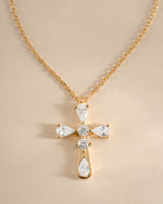 Close-up of Sami Jewels gold pear-cut cross necklace showcasing detailed craftsmanship on a chain.