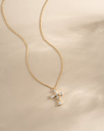 Gold pear-cut cross necklace by Sami Jewels displayed on a white background. Elegant jewelry piece with a detailed cross pendant.