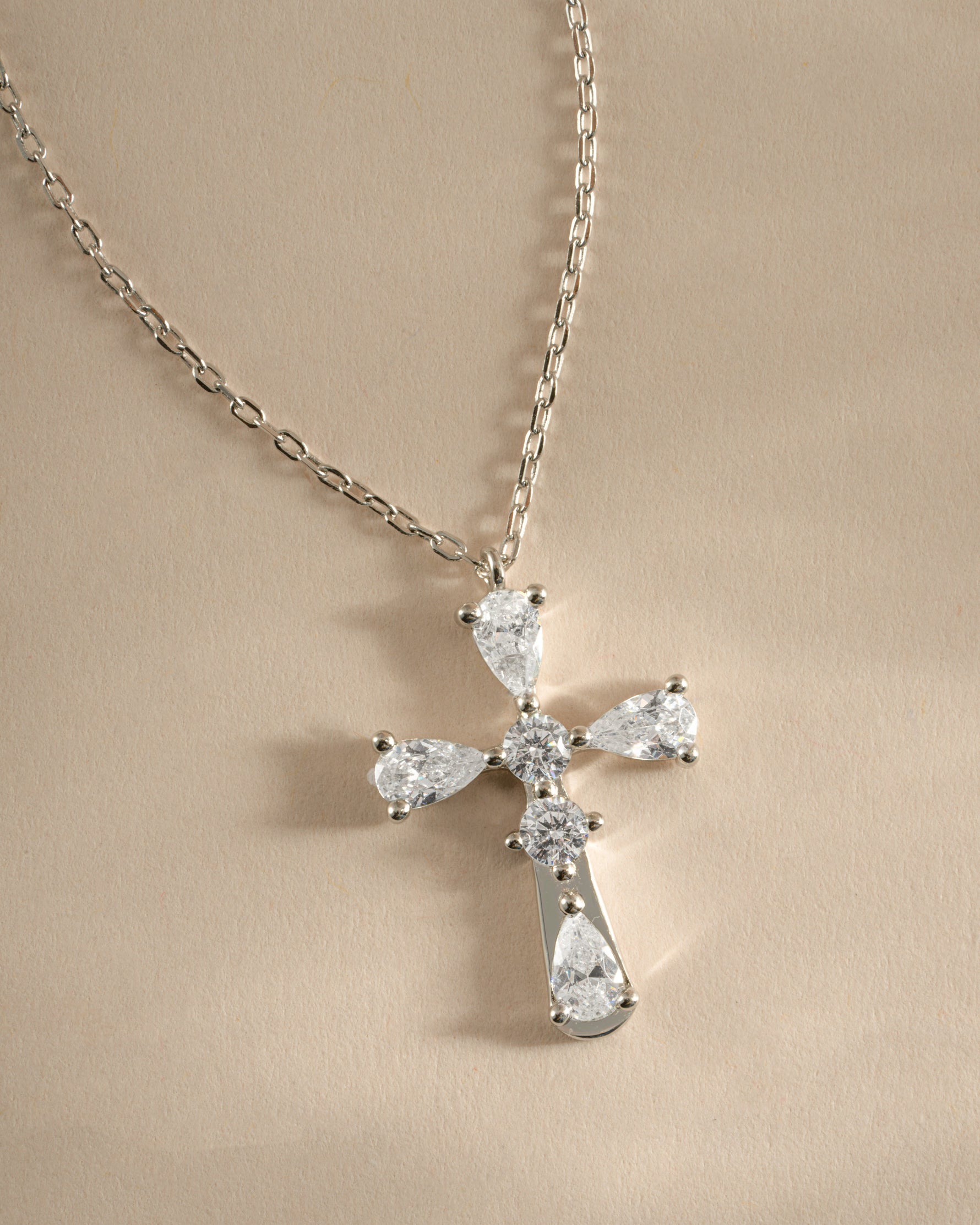 Close-up of Sami Jewels sterling silver pear-cut cross necklace showing detailed craftsmanship and elegant design.