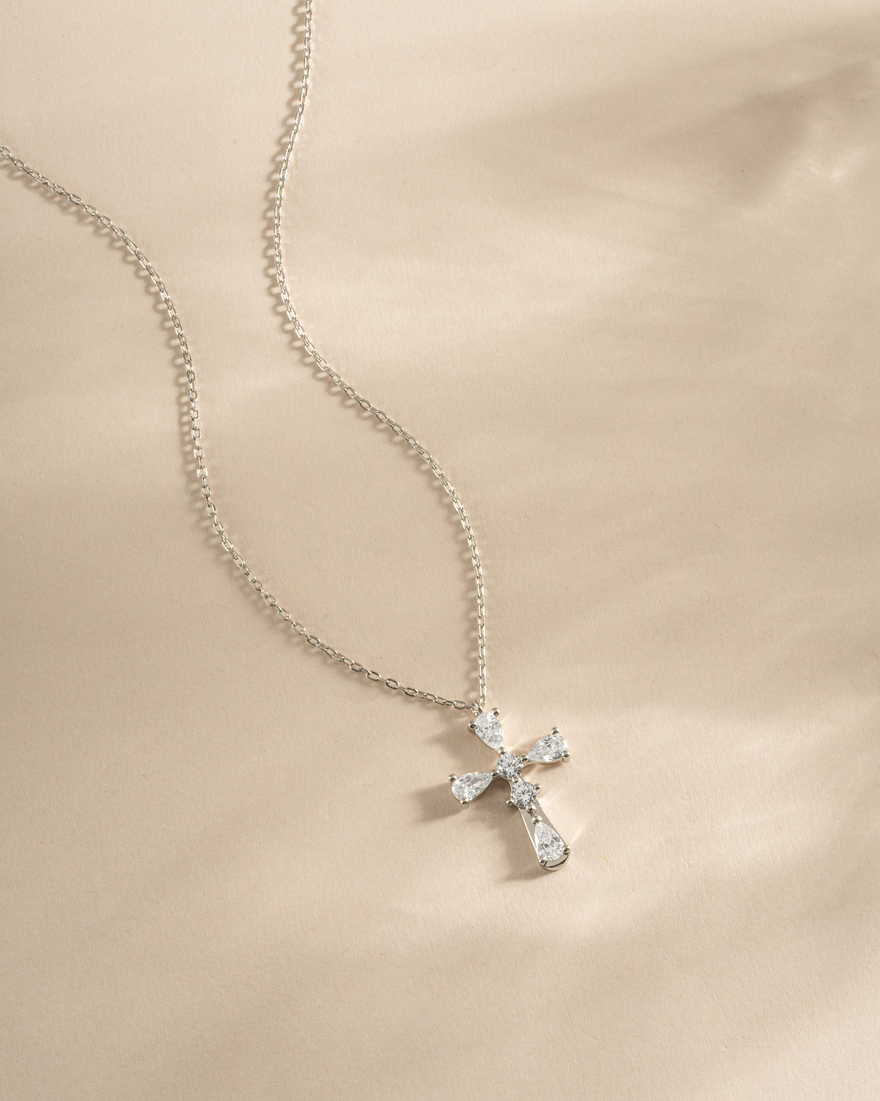 Sterling silver pear cut cross necklace from Sami Jewels, featuring a elegant pendant design displayed on a chain.