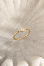 Gold pear-shaped ring from Sami Jewels, shown at an angled view highlighting its elegant gemstone cut and sleek design.