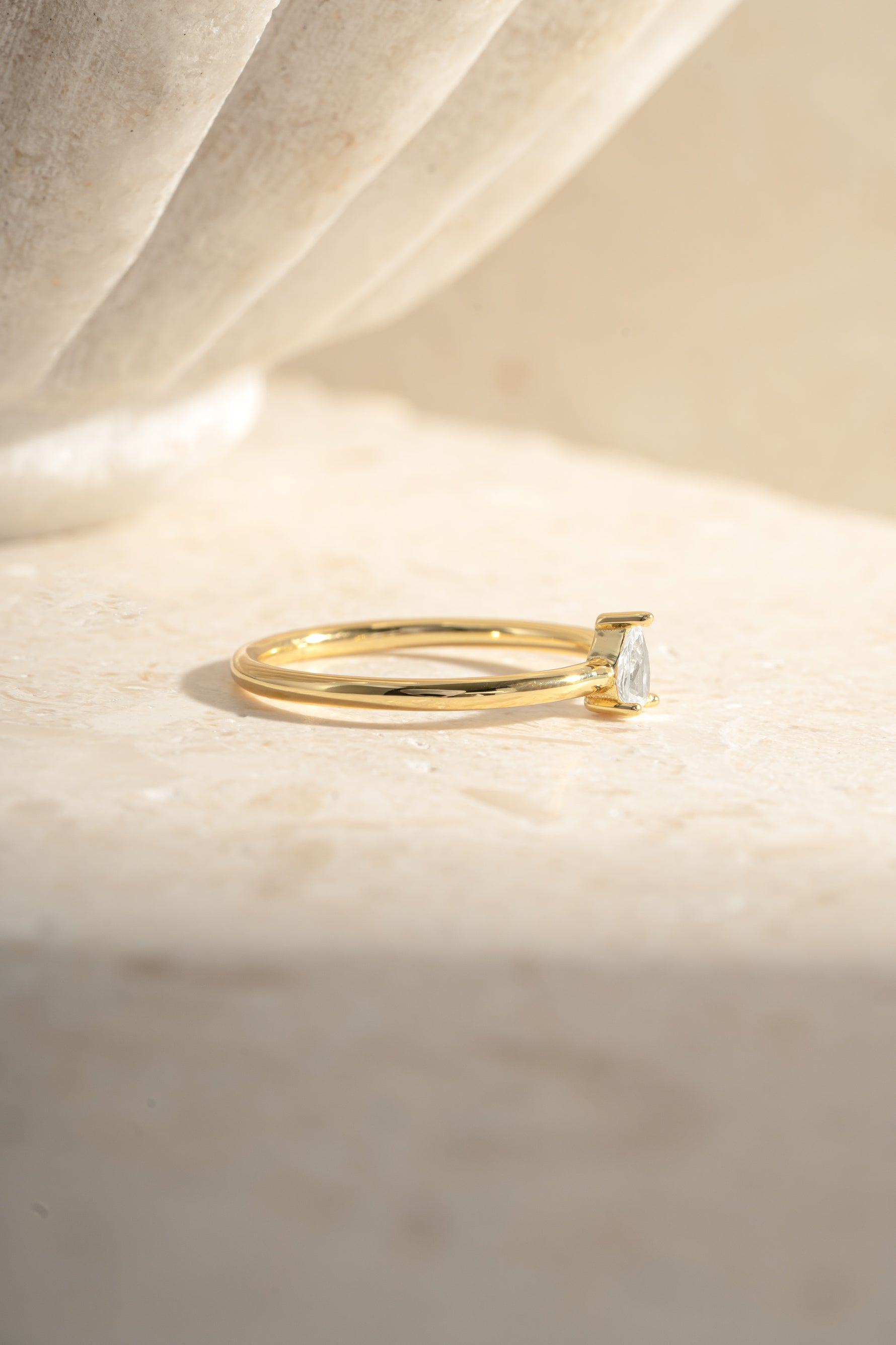 Gold pear-shaped ring from Sami Jewels, side view showing the elegant pear-cut design and smooth band.