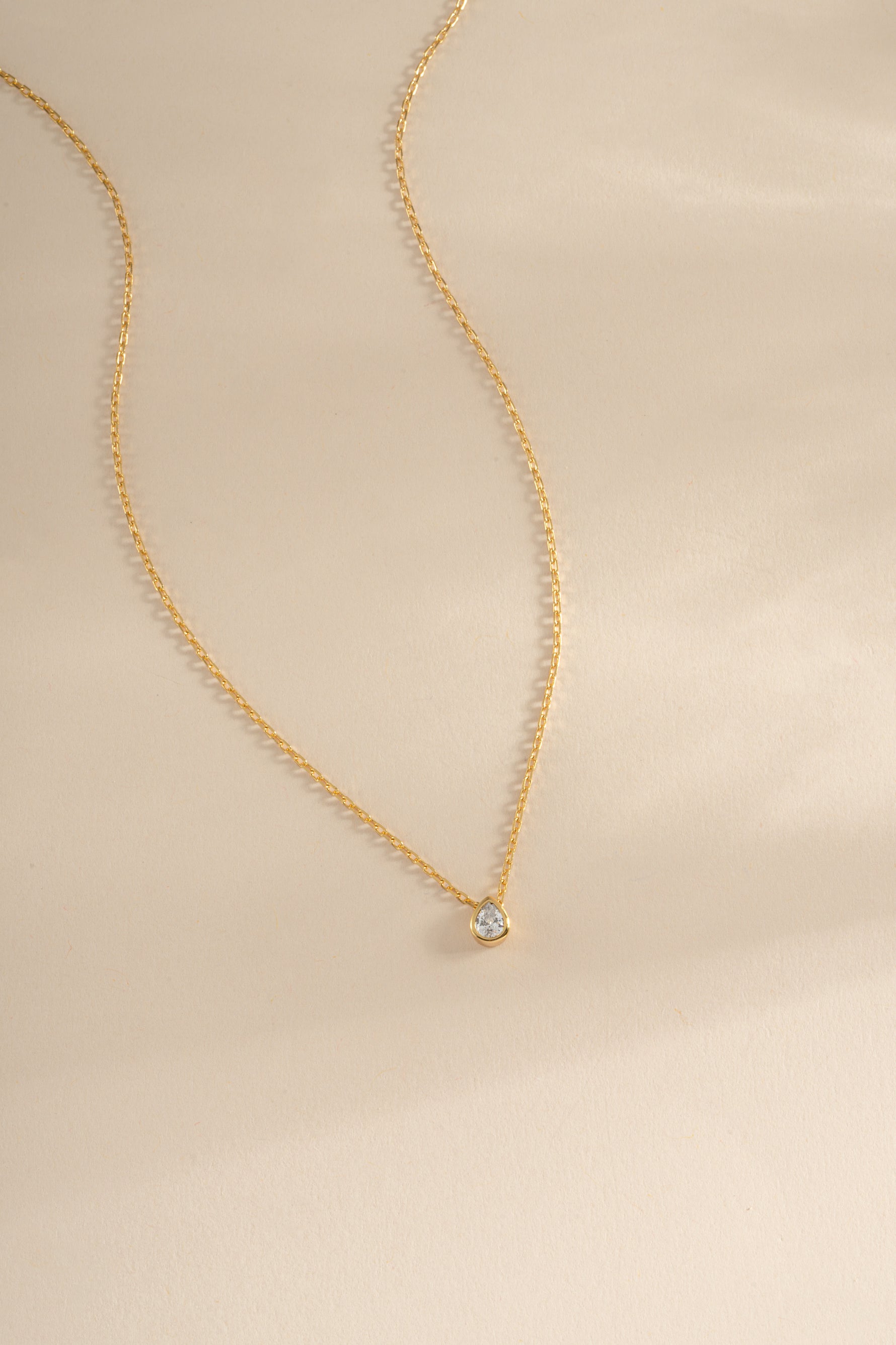 Gold tear drop pendant necklace with pear-shaped diamond by Sami Jewels, featuring an elegant and delicate design.